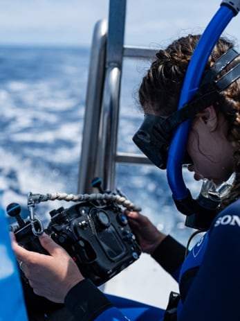 Plongeuse tenant un caisson vidéo sous-marin