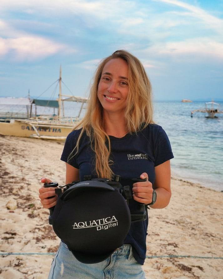 Margaux Le Brun on the beach, holding her Aquatica Digital underwater housing